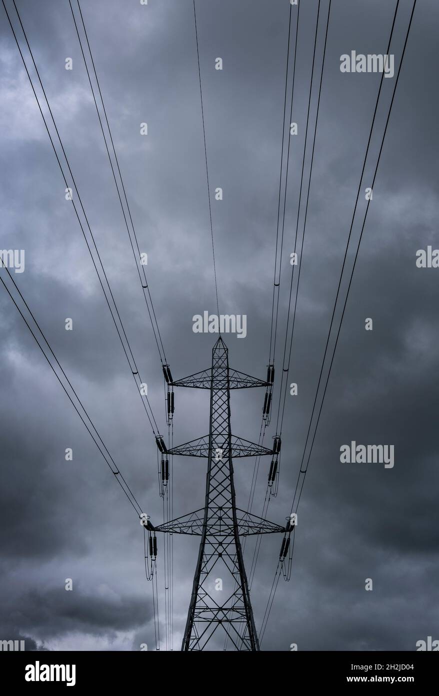 An electricity power supply pylon set against a heavily clouded grey sky, Worcestershire, England. Stock Photo
