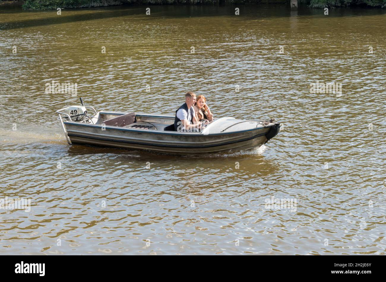 Couple in self drive motor pleasure boat on river dee hires stock