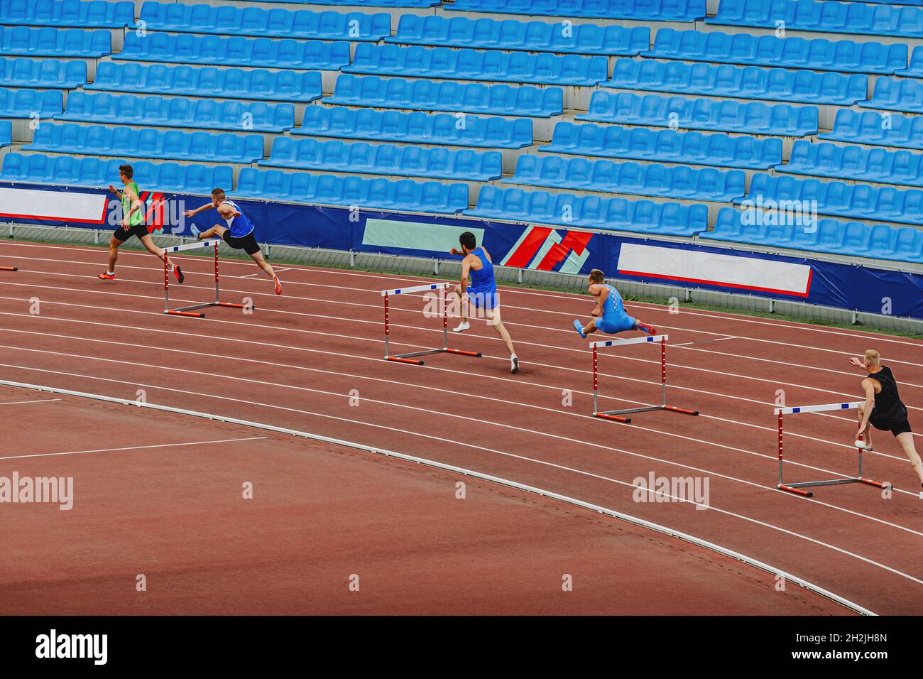 male runners 400 meter hurdles race at track and field competition