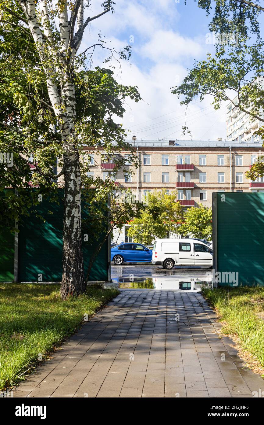 gates in noise barrier of road of Bolshaya Akademicheskaya street in Koptevo district of Moscow city after rain on sunny autumn day Stock Photo