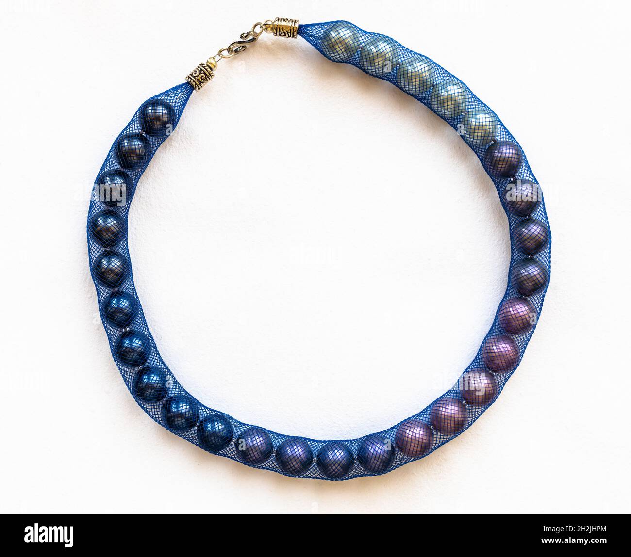 top view of round artificial pearl necklace in blue jewelry mesh on