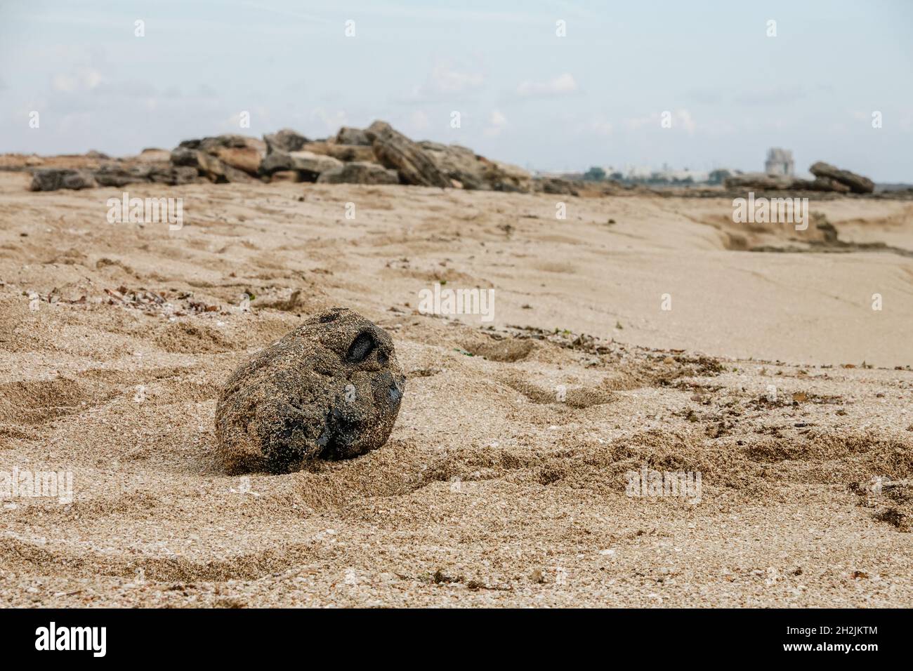 A block of black tar on the beach. Residue from hydrocarbon processing. There is a huge ecological problem in the Mediterranean sea. Stock Photo