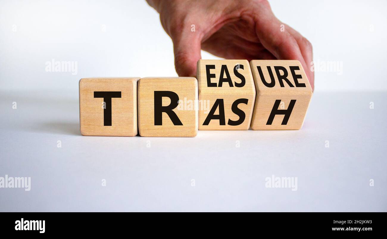 Trash to treasure symbol. Businessman turns cubes and changes the word trash to treasure. Beautiful white table, white background. Business, trash to Stock Photo
