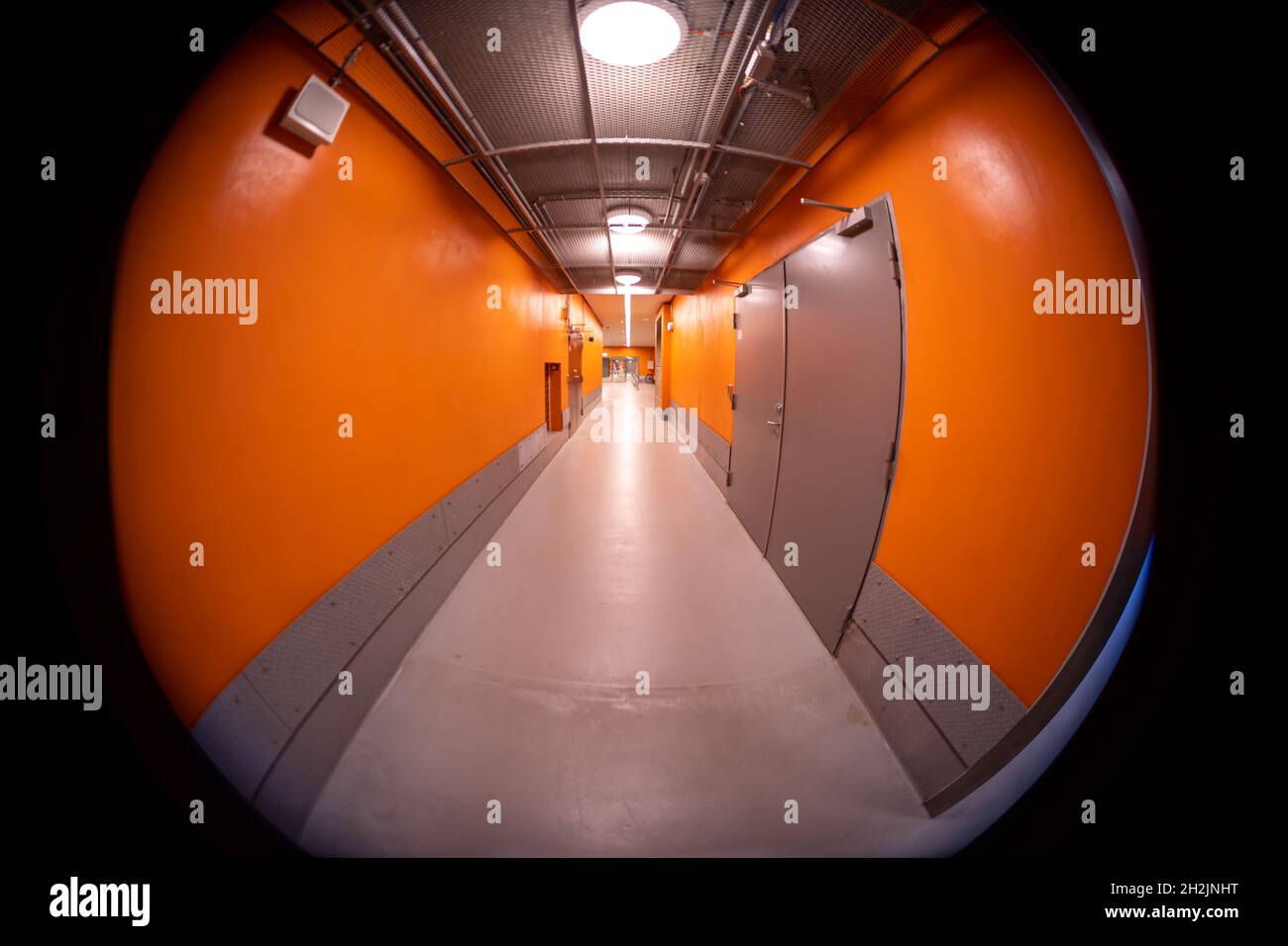 Narrow subway corridor with bright orange walls Stock Photo