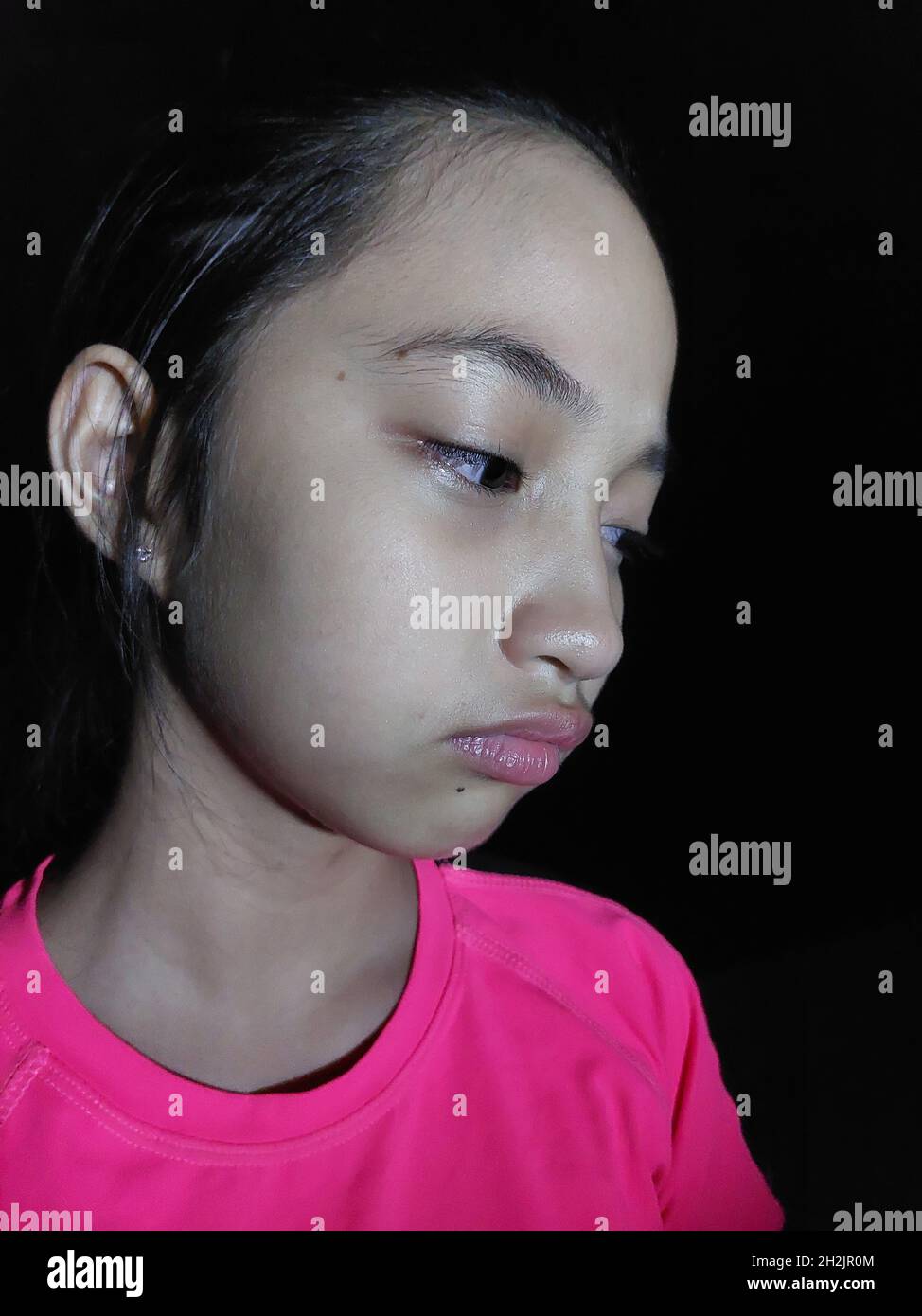 Unhappy Petite Asian Girl Child Isolated On Black Stock Photo