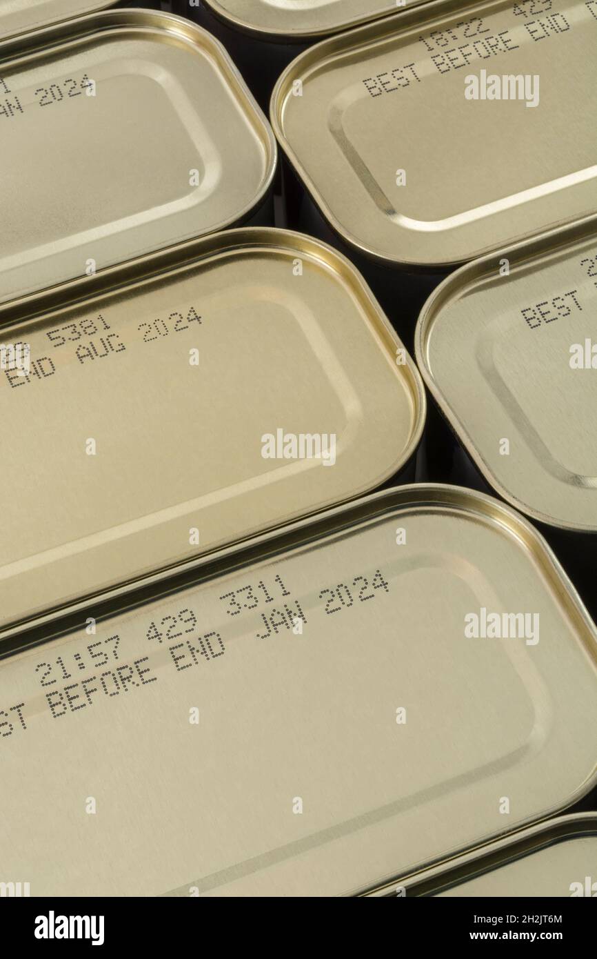 Abstract metal tin food cans with part of food Best Before Date visible. For food preservation, pandemic food shortages in UK, lockdown hoarding. Stock Photo