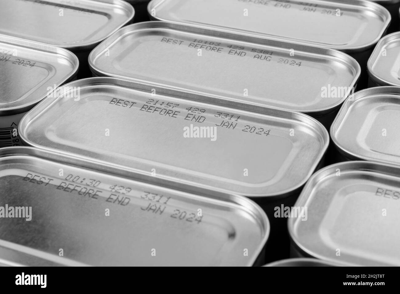 Monochrome abstract metal tin food cans with part of food Best Before Date. For food preservation, pandemic food shortages in UK, lockdown hoarding. Stock Photo