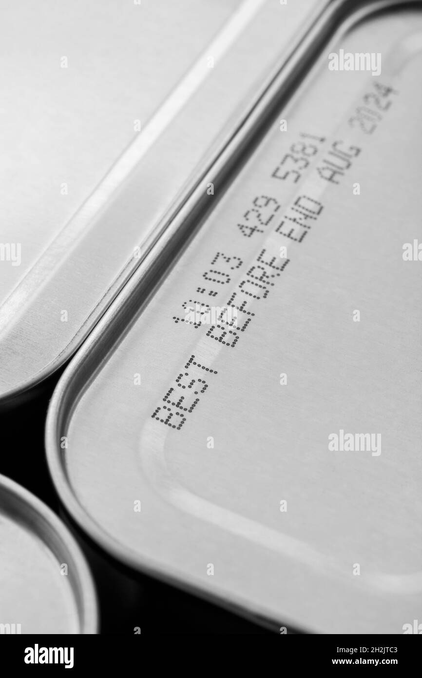 Monochrome abstract metal tin food cans with part of food Best Before Date. For food preservation, pandemic food shortages in UK, lockdown hoarding. Stock Photo