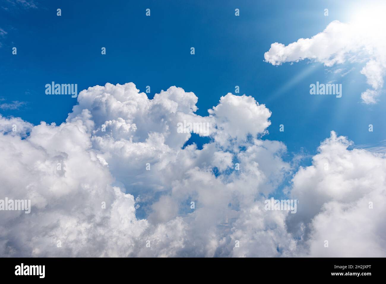 Beautiful blue sky with white cumulus clouds and sun rays (sunbeams ...