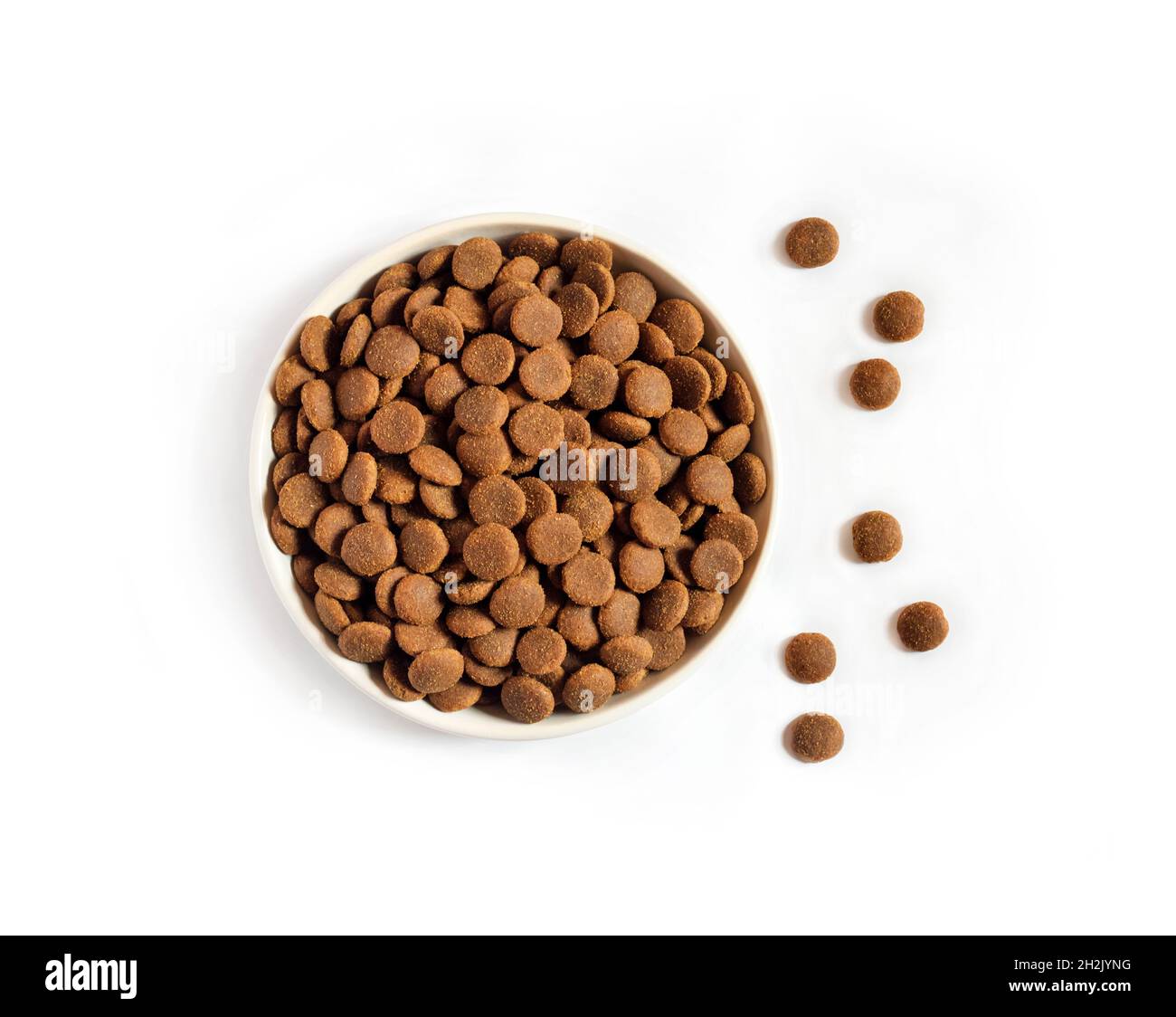 Dry pet food in a white ceramic bowl isolated on white background. Flat lay, top view. Copy space Stock Photo