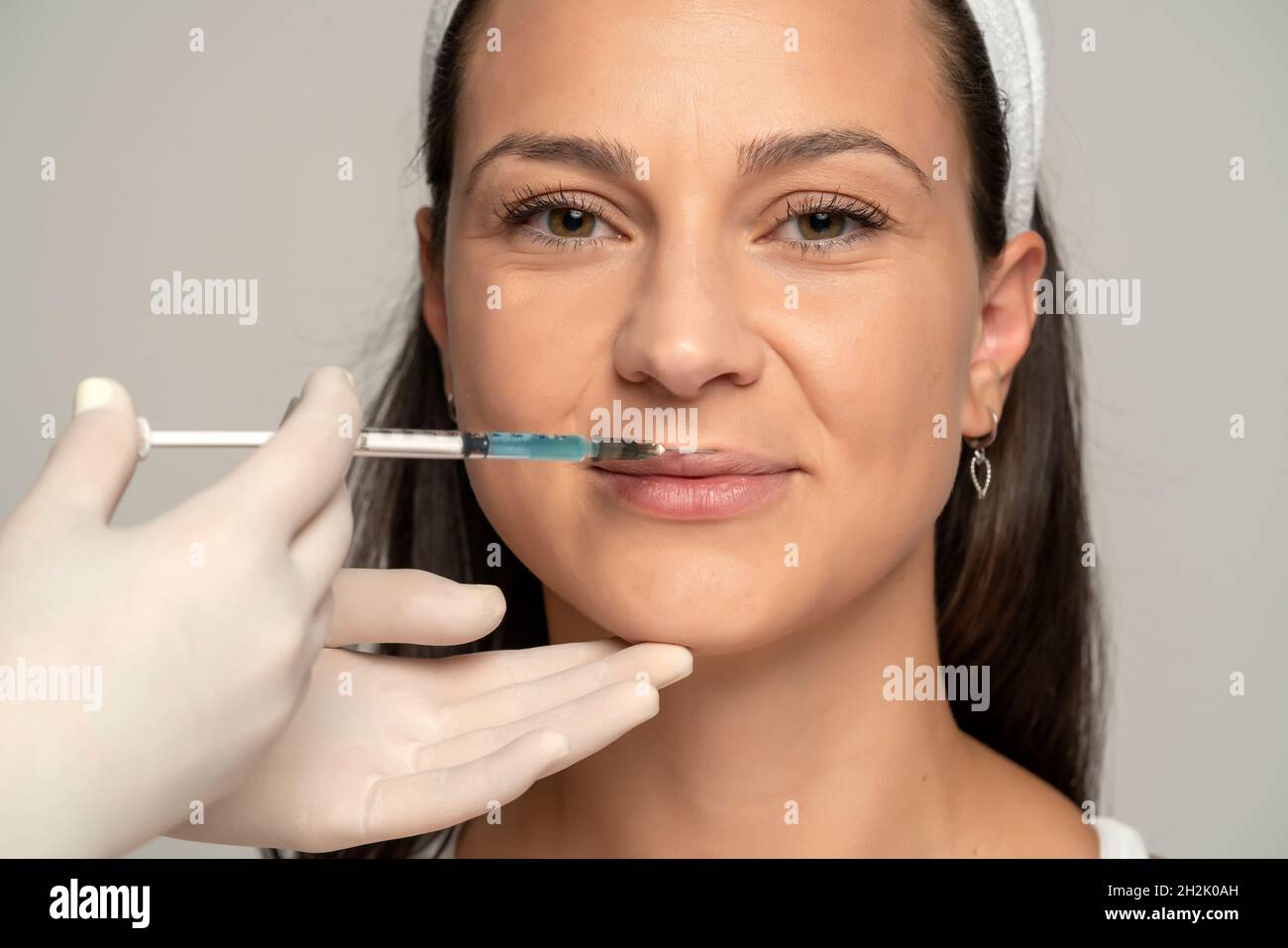 Portrait of a young satisfied woman on a lip filler injection procedure