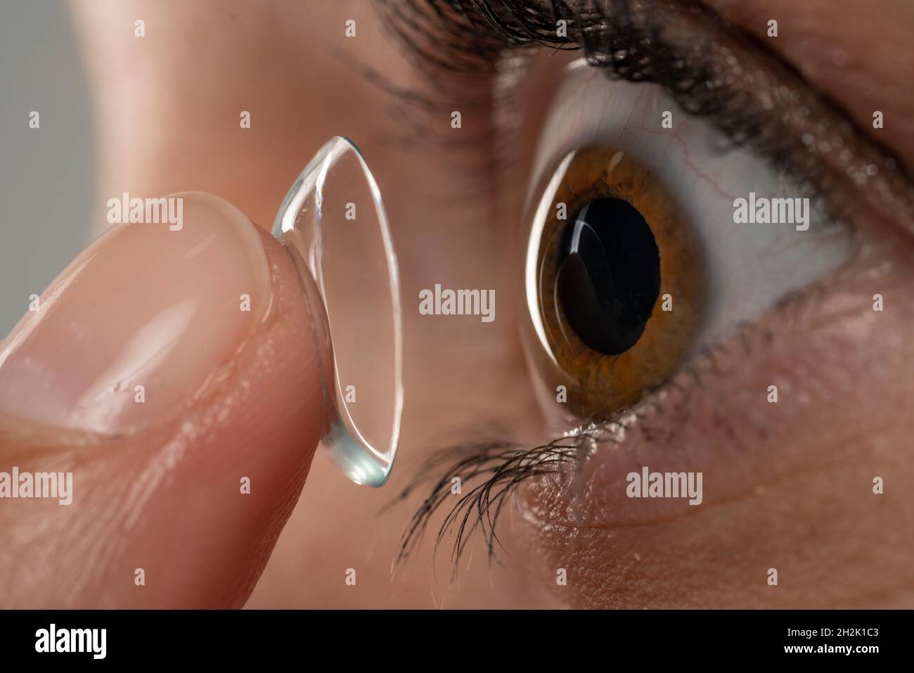 Closeup shot of young woman wearing contact lens. Side view Stock