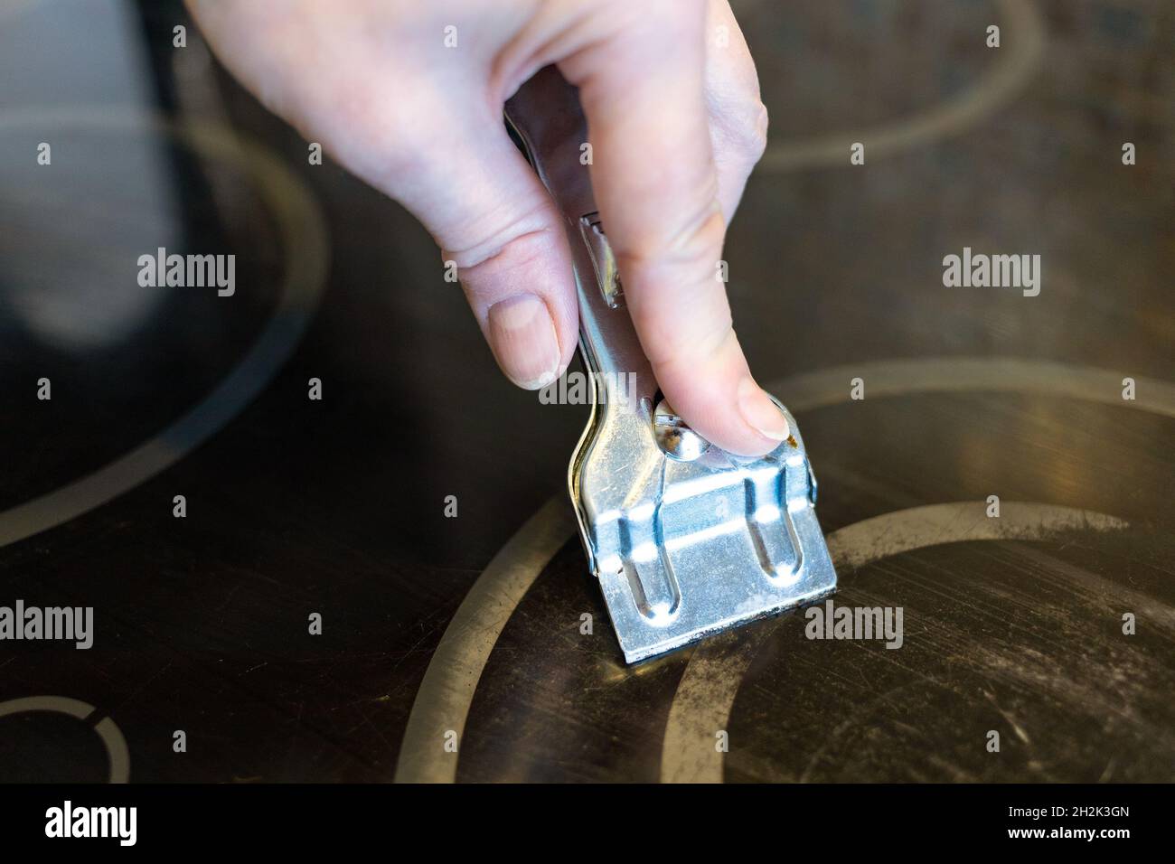 cleaning burnt black ceramic hob with razor close up Stock Photo Alamy