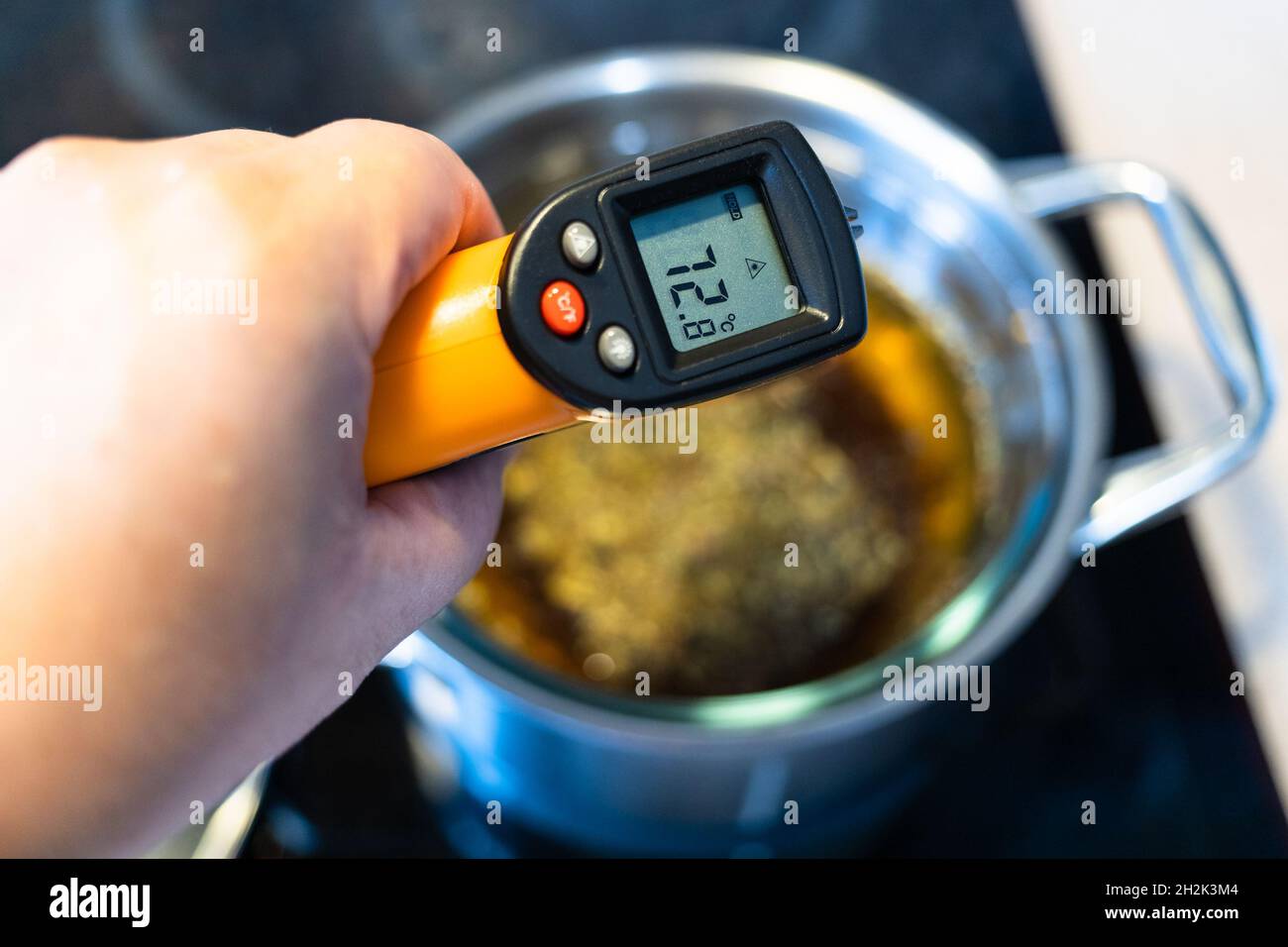 https://c8.alamy.com/comp/2H2K3M4/measuring-temperature-of-cooking-tincture-from-medicinal-herbs-in-water-bath-by-infrared-thermometer-on-ceramic-stove-at-home-kitchen-2H2K3M4.jpg