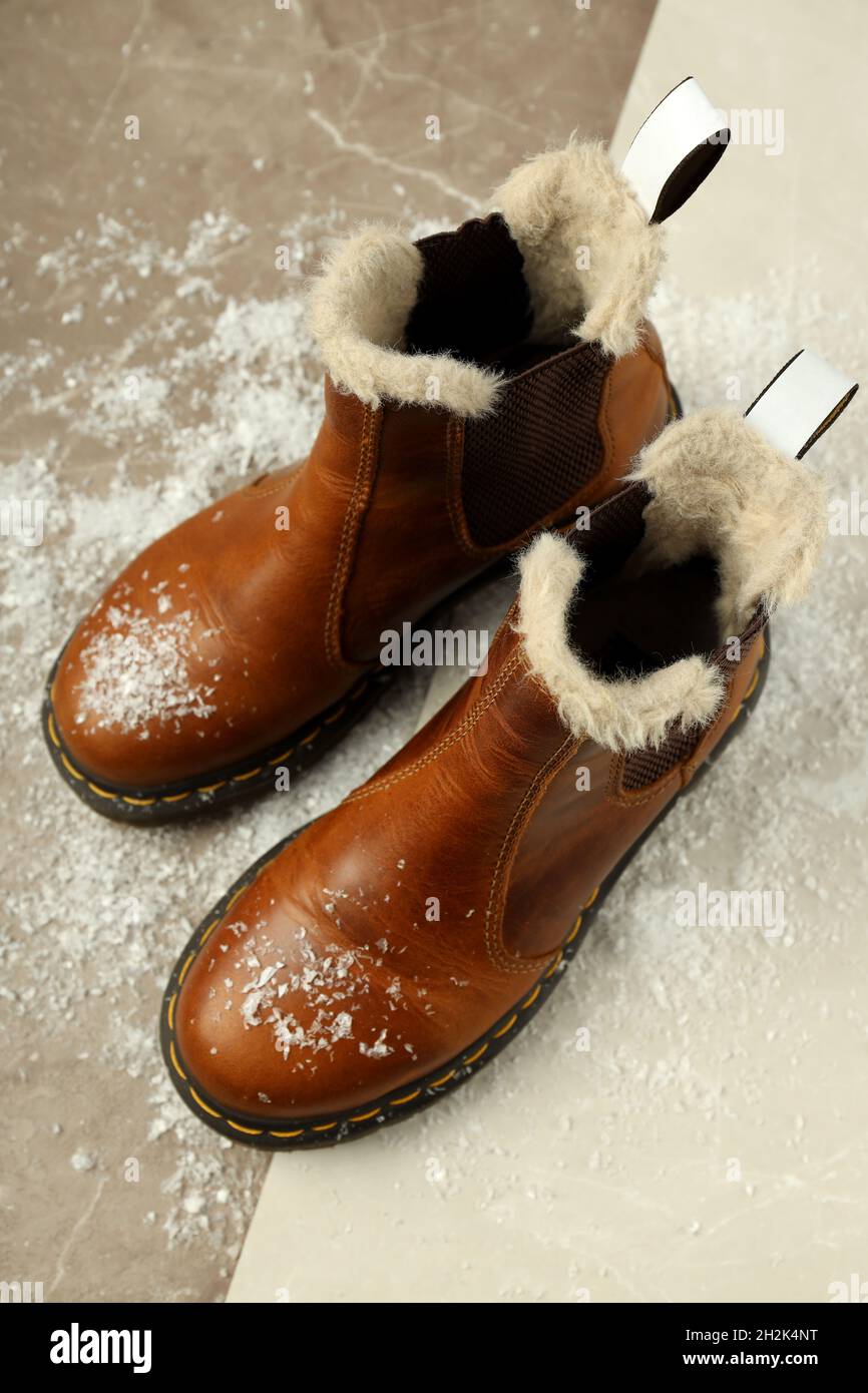 Boots with snow on two tone background. Stock Photo