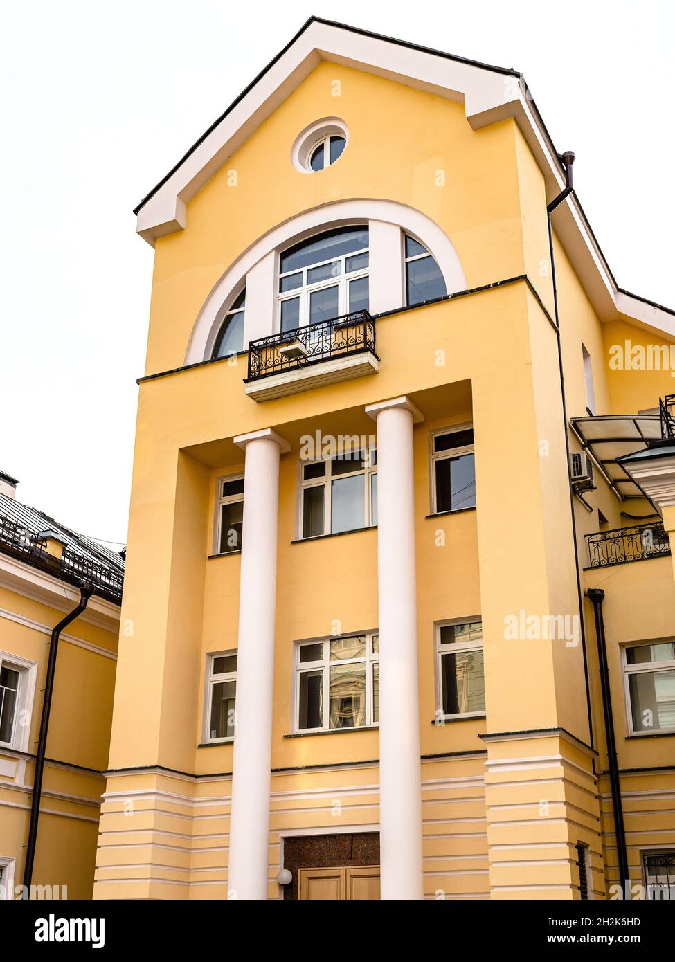 yellow facade with columns of building on Rozhdestvenka street in ...