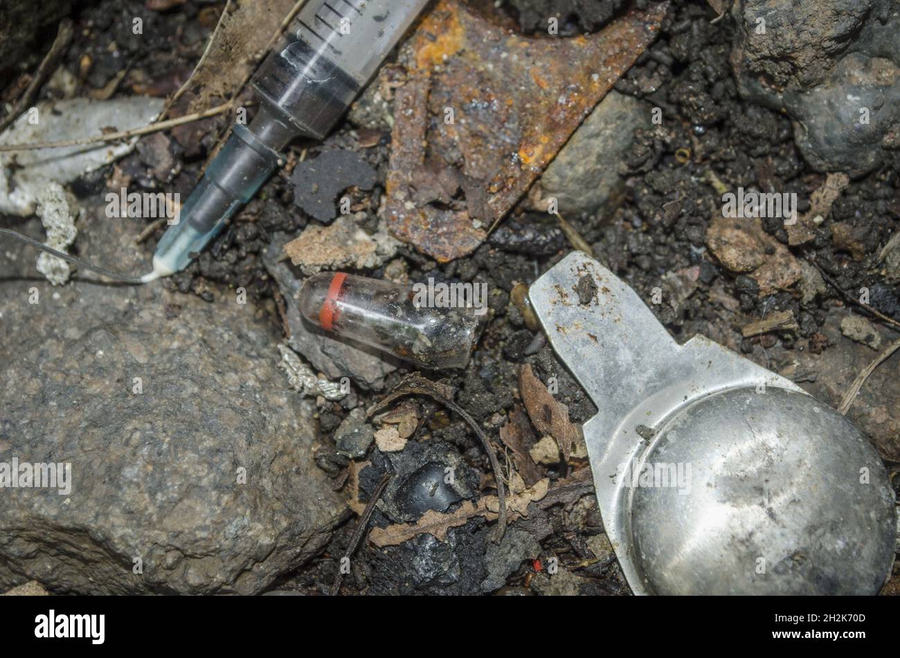 Closeup shot of a drug user's syringe and tackle on waste ground in the inner-city area. Stock Photo