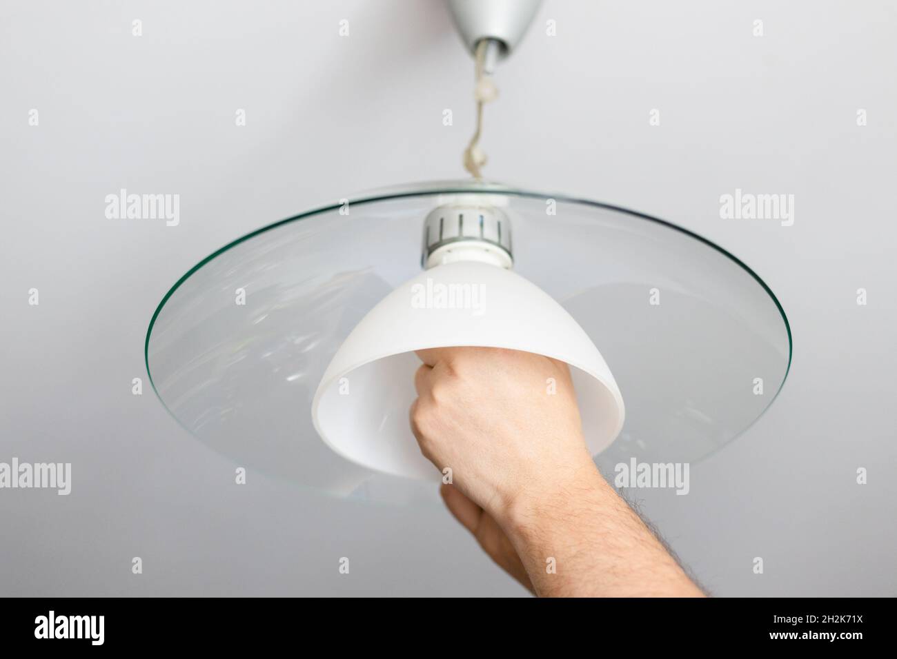 man installs lampshade of ceiling lamp at home Stock Photo - Alamy
