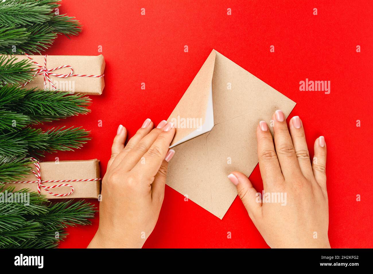 woman hands send letter with Christmas greetings in frame of fir ...