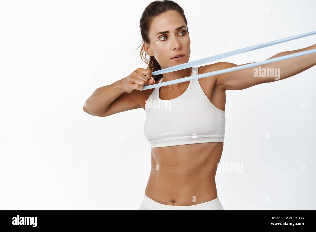 Fit and healthy sportswoman stretch fitness band female athlete workout with elastic stretching rope in gym standing over white background Stock Photo Alamy