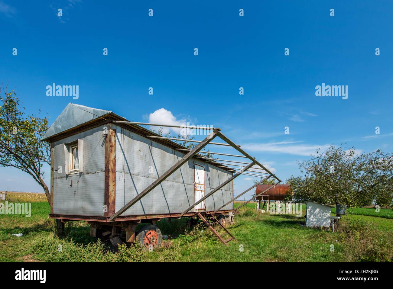 vintage mobile prefabricated house installed in a field with water tank Stock Photo