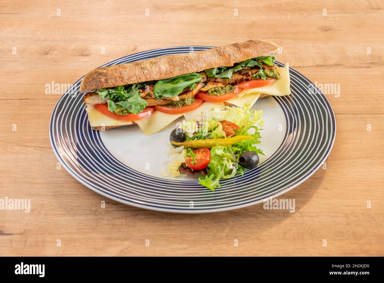 https://c8.alamy.com/comp/2H2KJDX/ciabatta-bread-sandwich-with-fried-chicken-kale-basile-caprese-sauce-tomato-and-cheese-with-black-olives-pickled-piparra-and-lettuce-2H2KJDX.jpg