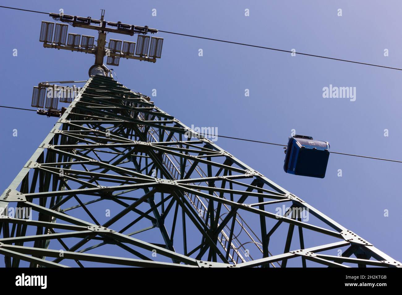 Cable car by steel hight tower from below. Tourist attraction concept ...