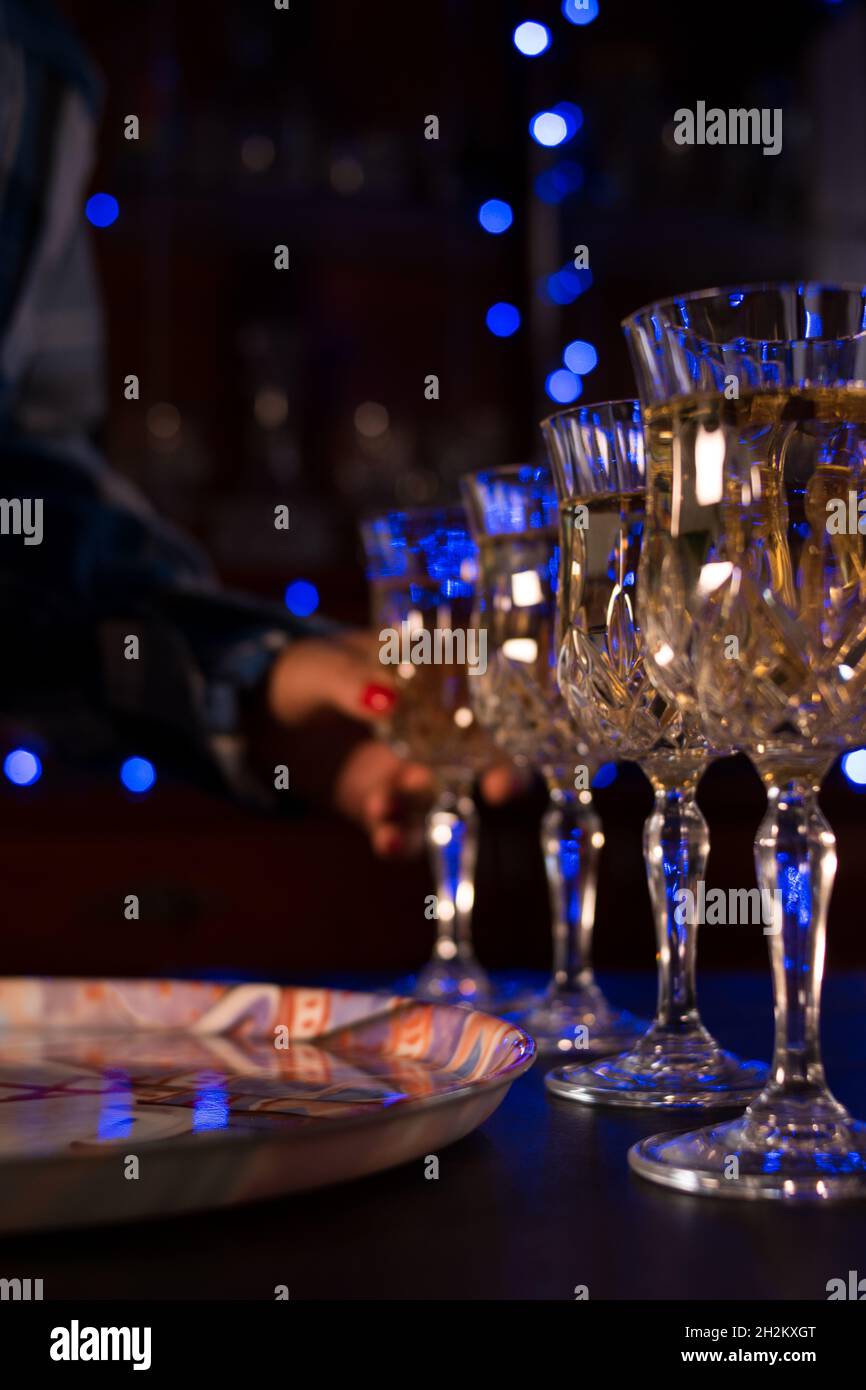 Woman serving several glasses of champagne in a bar Stock Photo