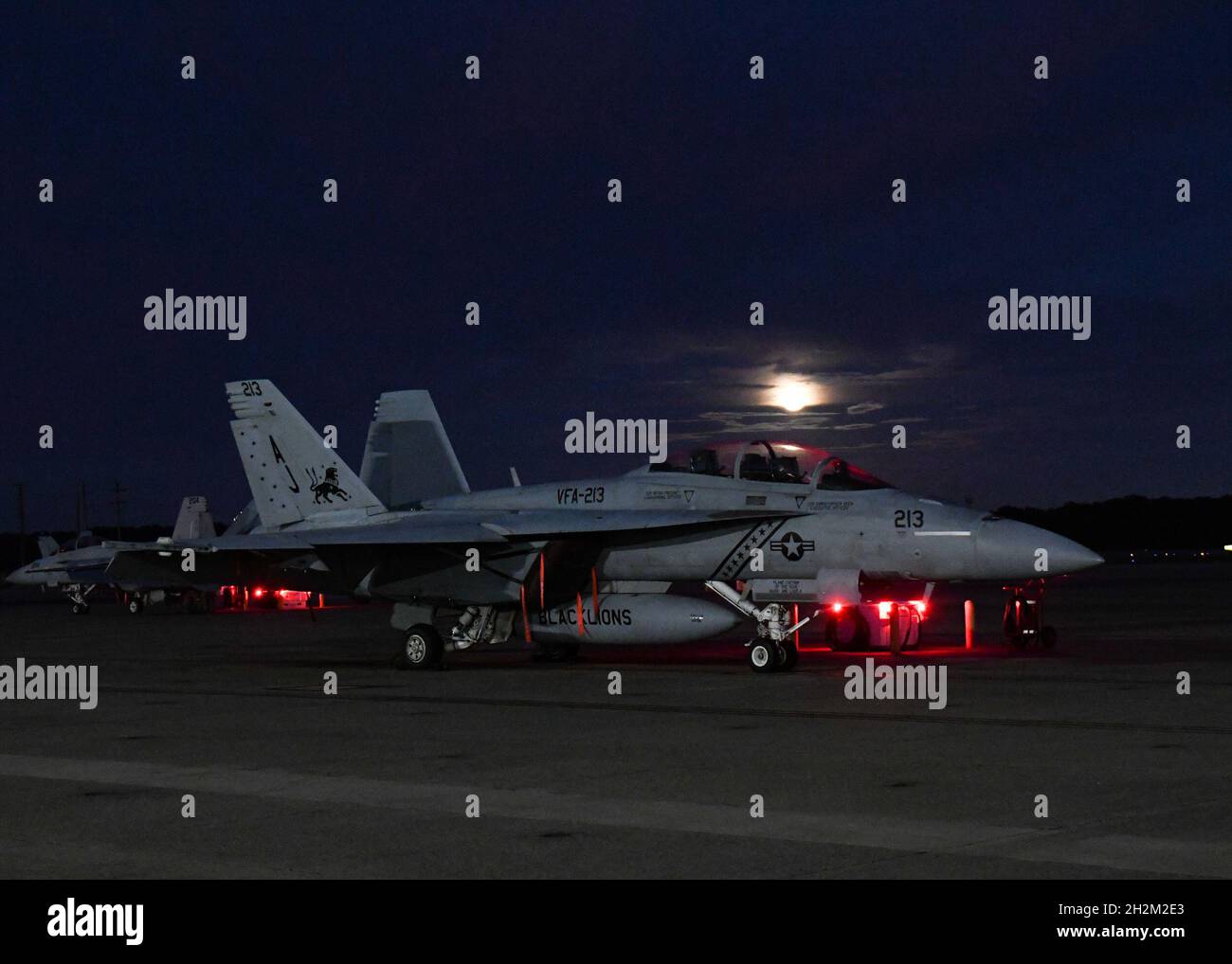 211020-N-AC802-0131 VIRGINIA BEACH, Va. (Oct. 20, 2021) The moon sets over an F/A-18E Super Hornet, attached to the “Blacklions” of Strike Fighter Squadron (VFA) 213 on the flight line of Naval Air Station Oceana. The squadron is assigned to Carrier Air Wing Eight, based at Naval Air Station Oceana. (U.S. Navy photo by Mass Communication Specialist 2nd Class Megan Wollam/Released) Stock Photo
