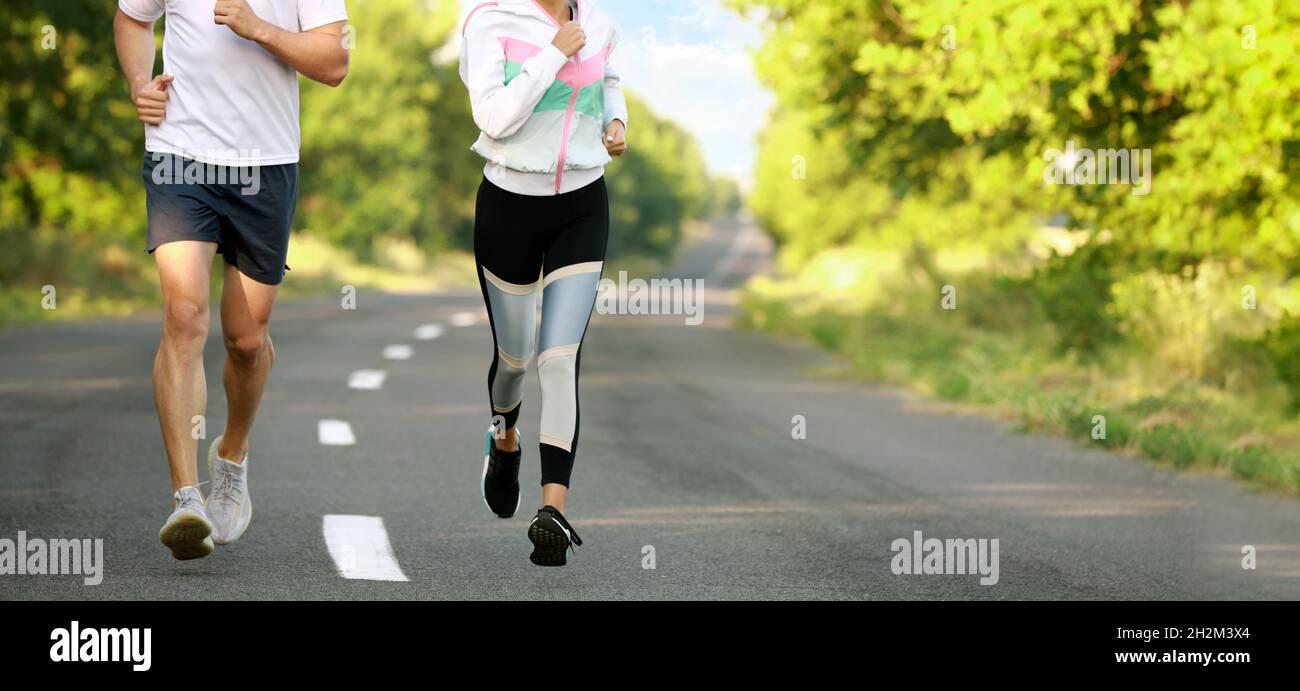 Sporty young couple running outdoors Stock Photo - Alamy