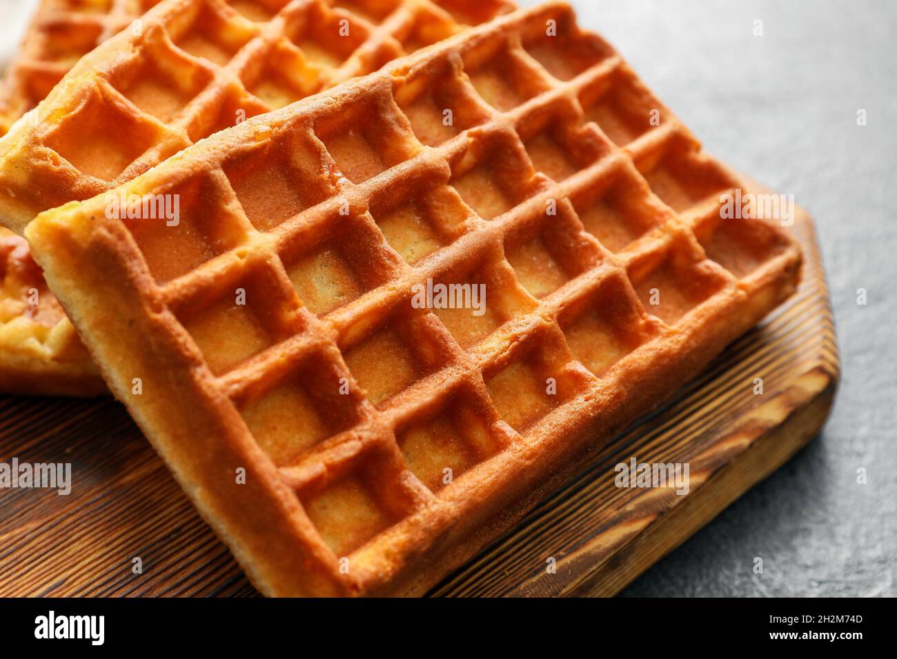 Board with delicious Belgian waffles on table, closeup Stock Photo Alamy