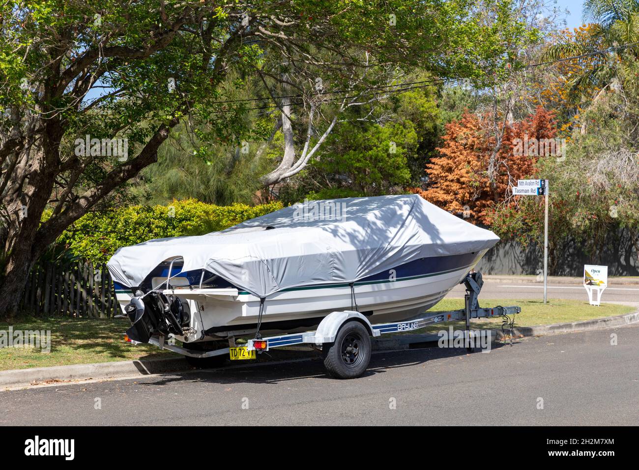 Boat on a trailer and covered parked in Sydney street in North Avalon