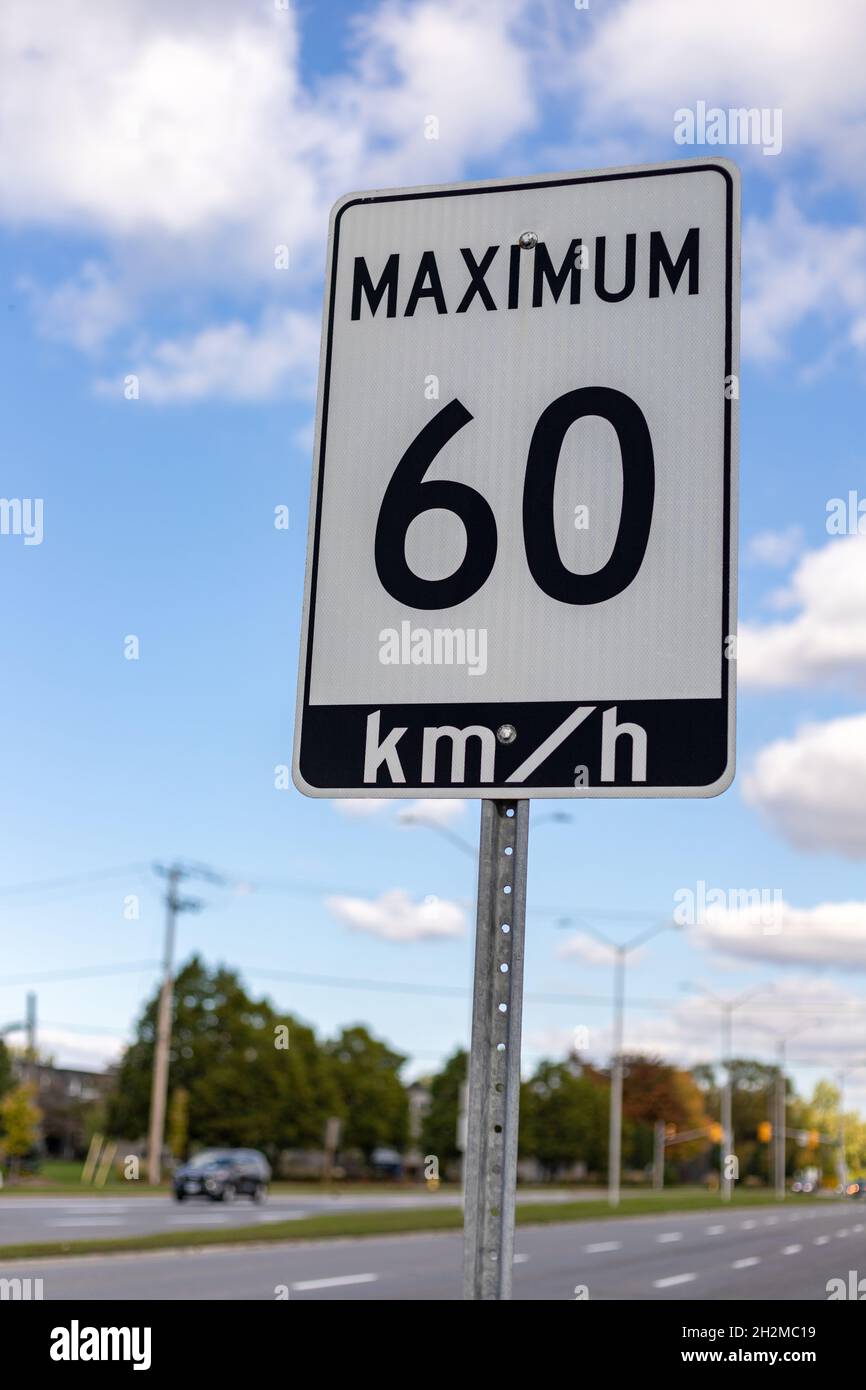 Speed limit road sign in the street against blue sky, 60 km per hour