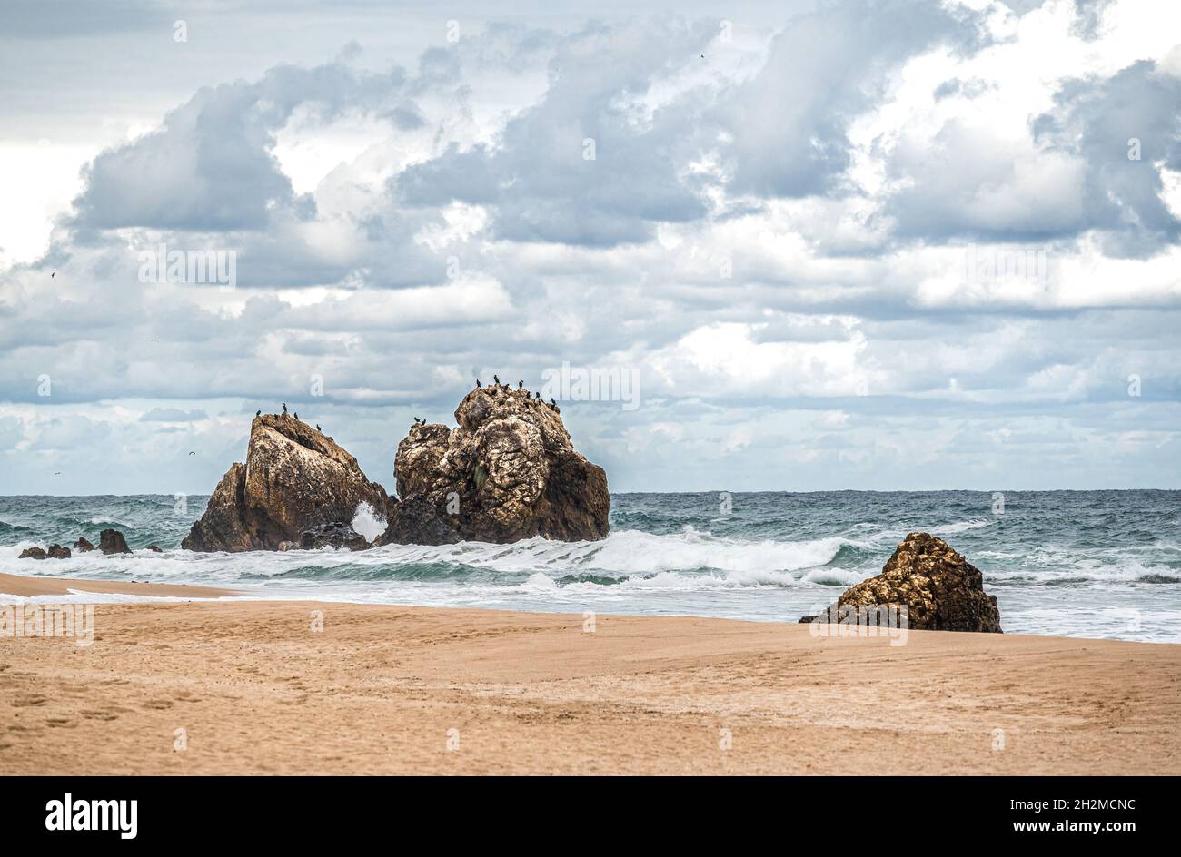 Sandy beach with large rocks hi-res stock photography and images - Alamy