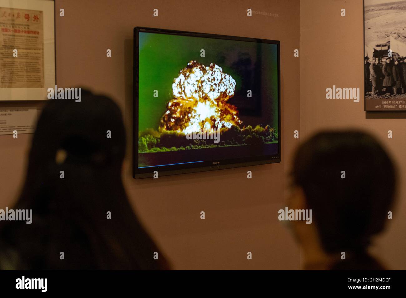 Chinese visitors watch the video of the first atomic bomb explosion on October 16, 1964 in the National Museum of China. 23-Oct-2021 Stock Photo