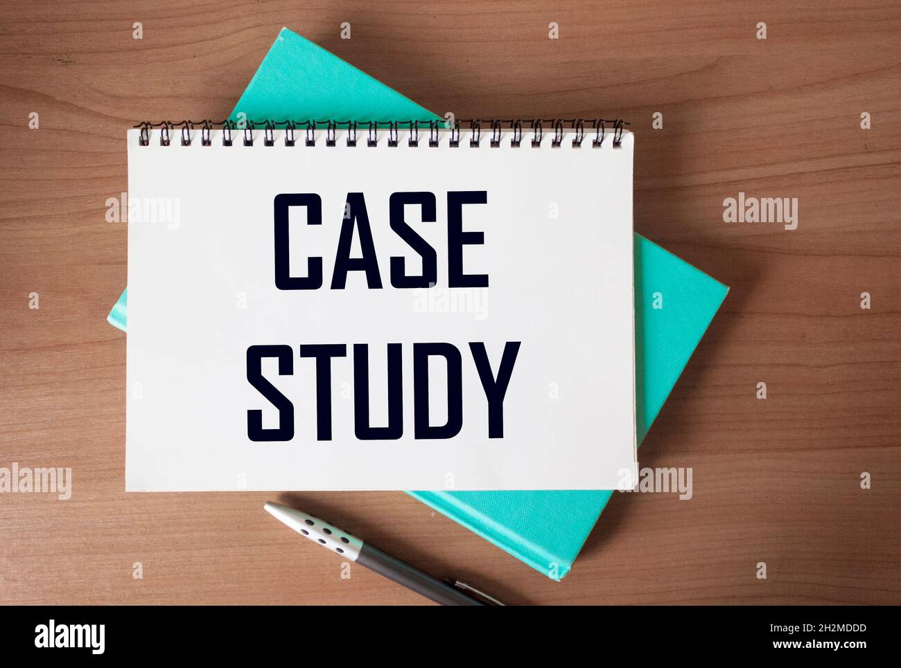 The text Case study is written on a notebook and a wooden table Stock Photo