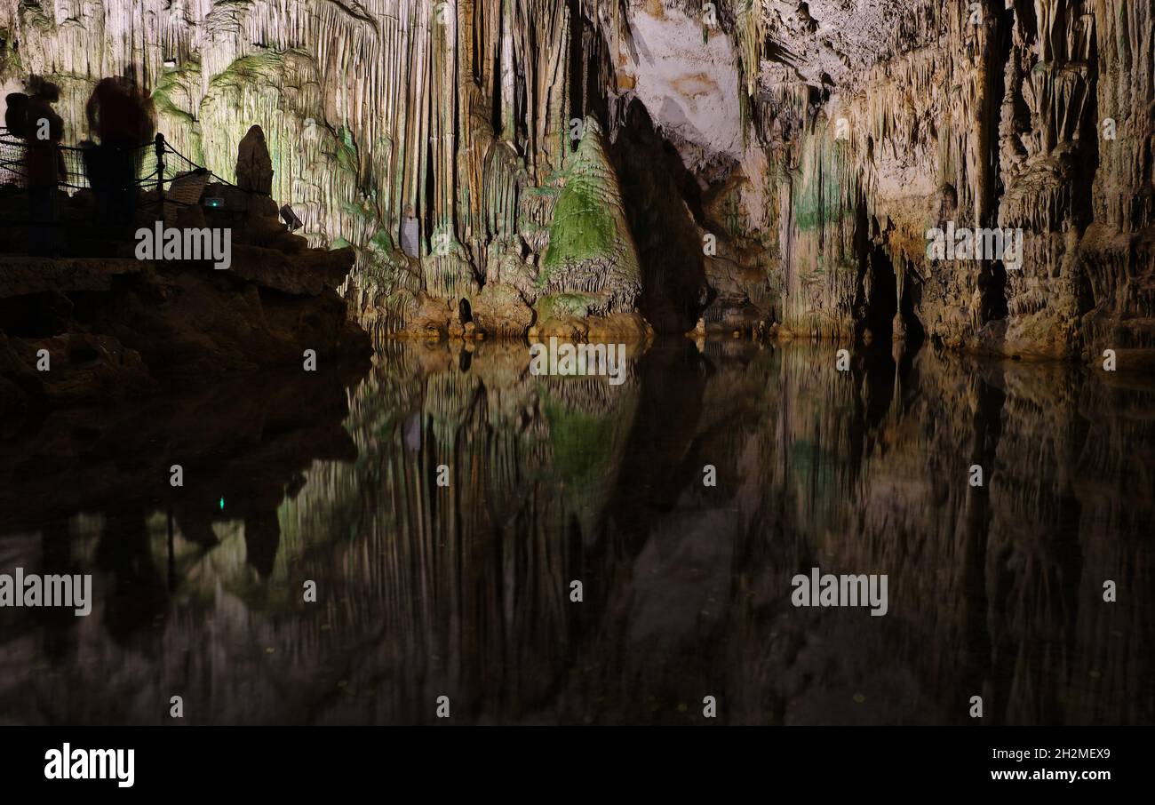Ancient cave in north Sardinia with internal lake, reflections, stalactites and stalagmites Stock Photo