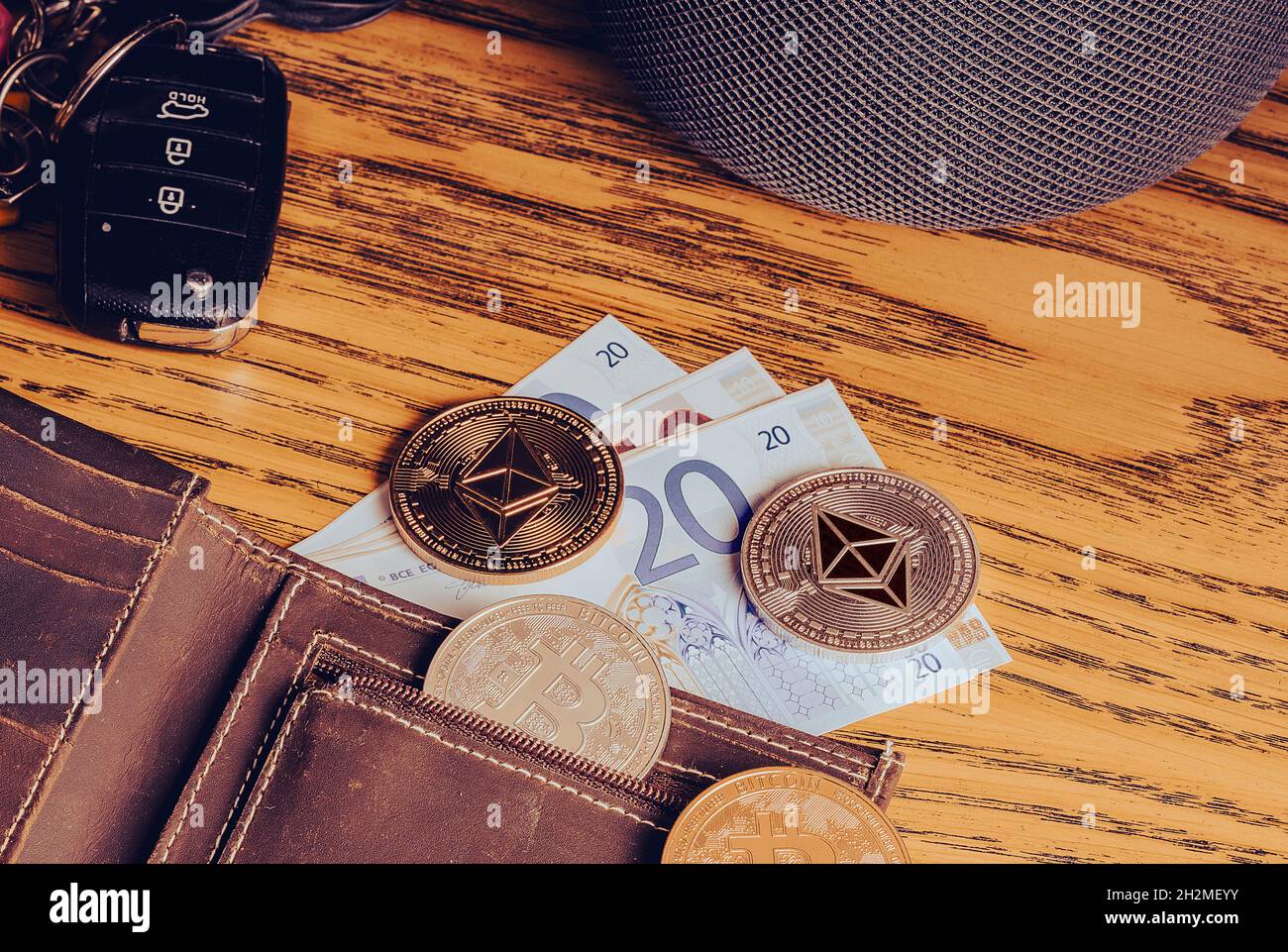Bitcoin and Ethereum coins on a leather wallet with car keys on an old  wooden tabletop. Flat lay, high quality Cinematic atmosphere photo Stock  Photo - Alamy