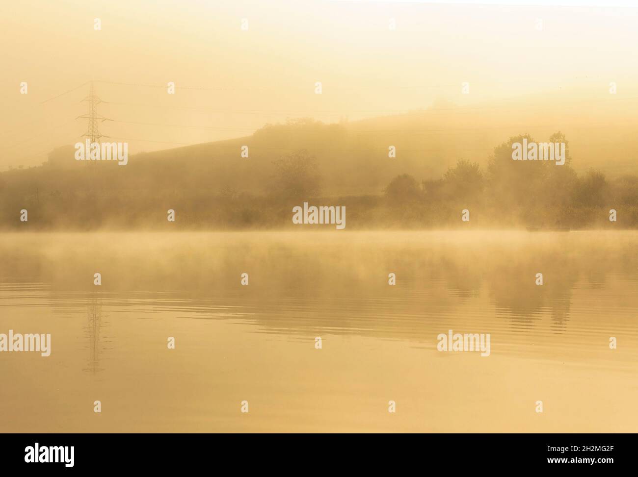 misty morning over the lake, image taken in the golden light of dawn at Sacalaia, Transilvania Stock Photo