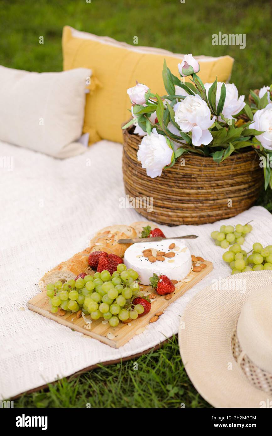 Picnic basket with food on green sunny lawn Stock Photo - Alamy