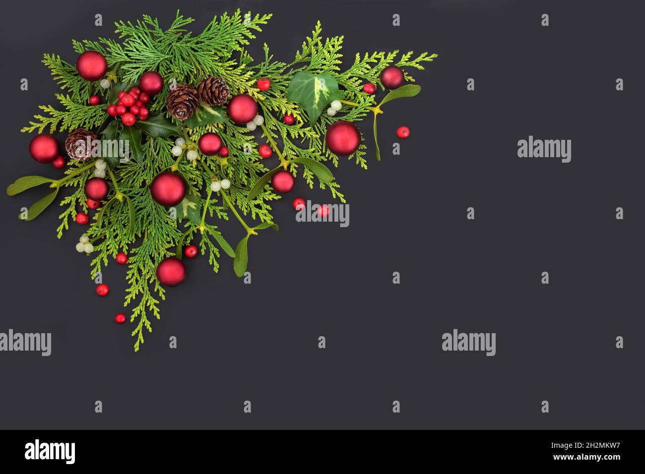 Kostbar Rosefarve Overdreven Christmas red bauble and flora decoration. Winter holly, red berries,  mistletoe and greenery. Minimal Xmas festive nature concept. On dark grey  Stock Photo - Alamy