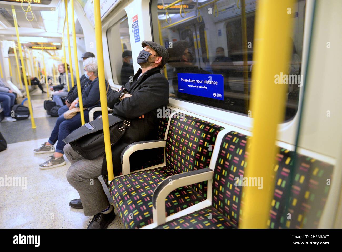 London, England, UK. Passengers on a tube train wearing COVID masks