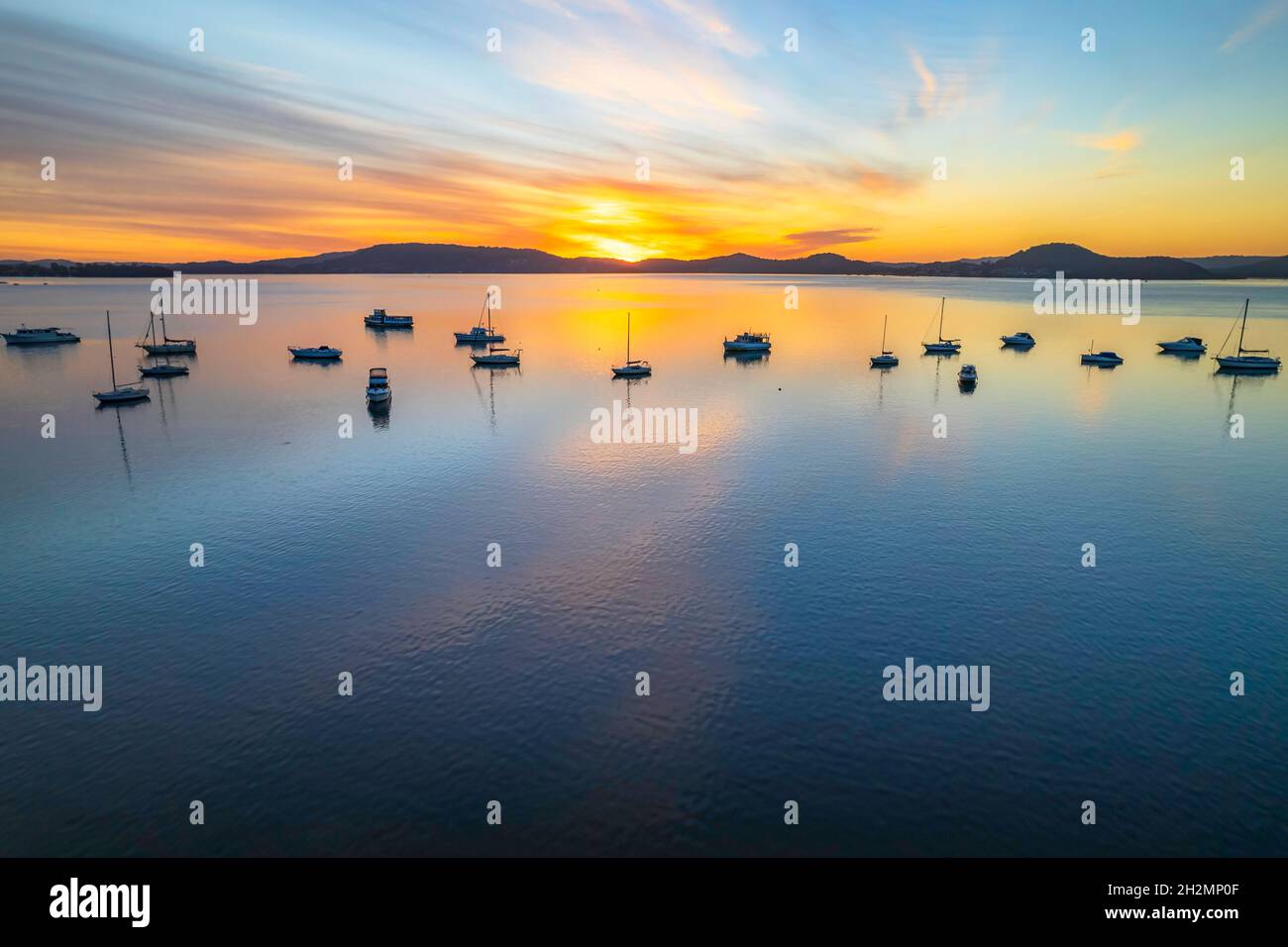 Sunrise with boats and streaky high cloud at Koolewong Waterfront on the Central Coast, NSW, Australia. Stock Photo