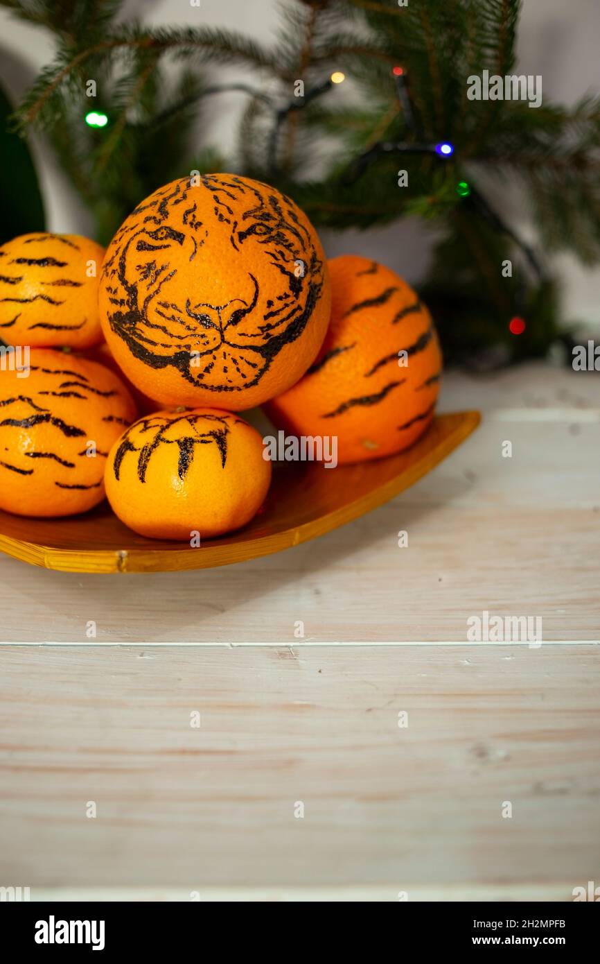 oranges on a yellow wooden plate. 2022 year of the tiger concept Stock Photo