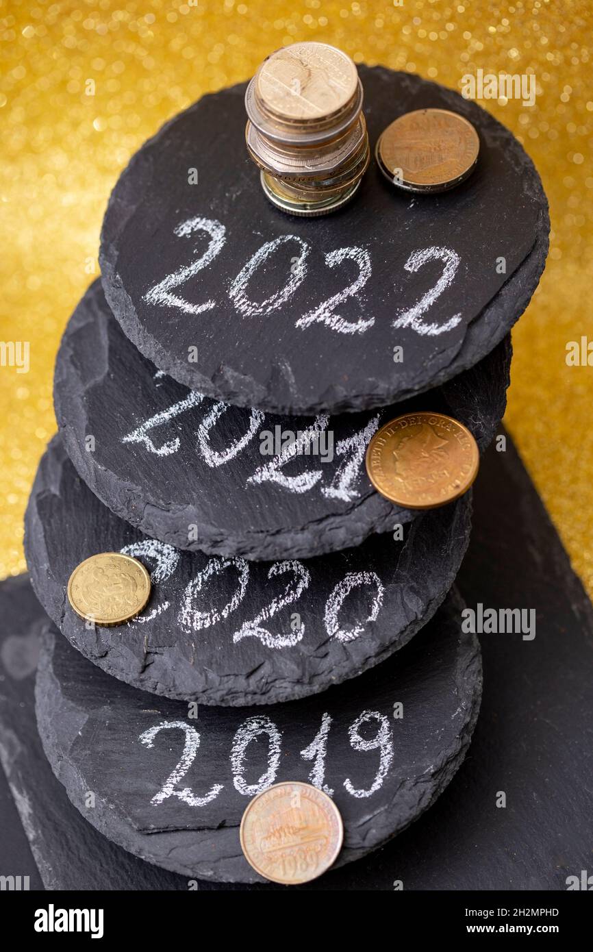 2022, 2021, 2020 and 2019 numbers written on staked black stone tiles representing past and future years. Wealth wishes for the new year Stock Photo