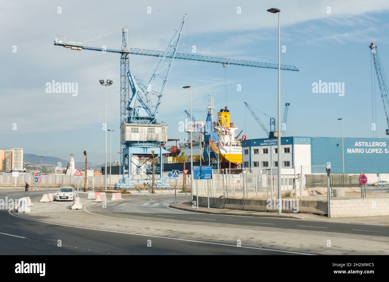 Old blue crane in industrial setting, port of Malaga, Spain. Stock Photo