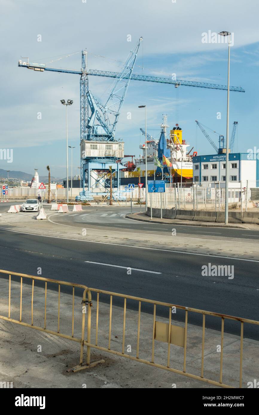 Old blue crane in industrial setting, port of Malaga, Spain. Stock Photo