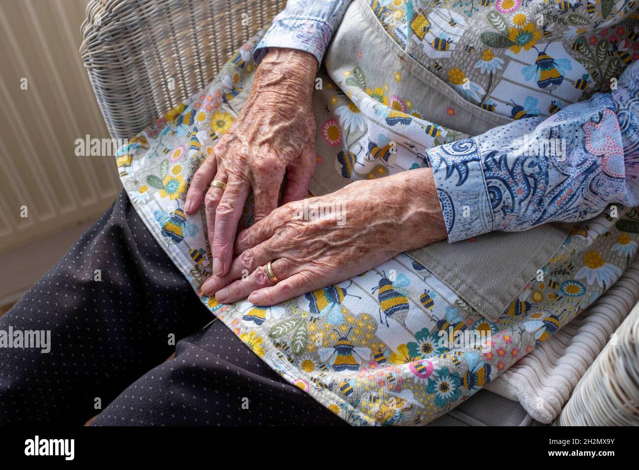 Elderly woman in her 80s holding her hands on her lap UK Stock Photo