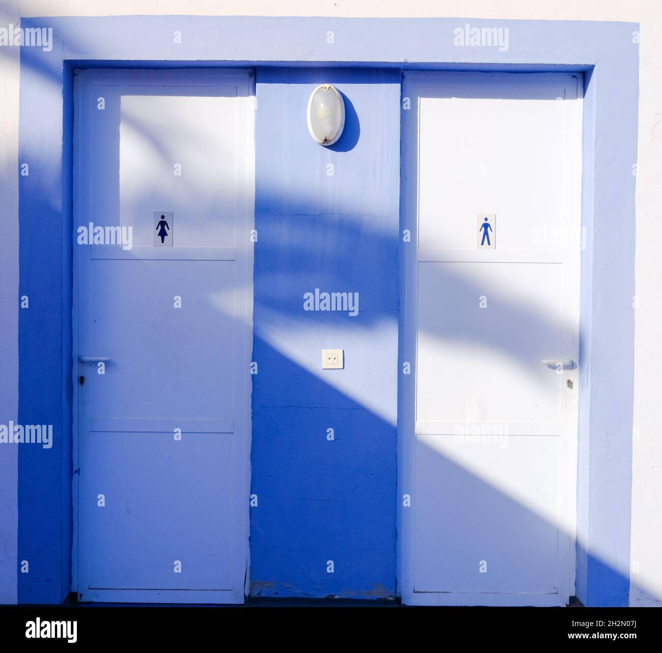 bathroom doors. white and light blue. man and woman Stock Photo Alamy