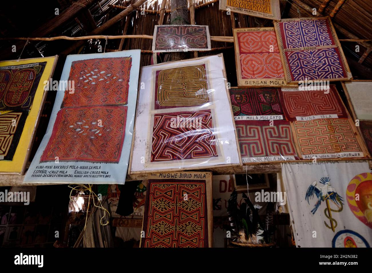 A selection of different design patterns of traditional elaborate embroidered hand stitched Molas worn by local women displayed in a small museum of culture focusing on local traditions in Carti Sugtupu island village administered by Guna natives known as Kuna in the 'Comarca' (region) of the Guna Yala located in the archipelago of San Blas Blas islands in the Northeast of Panama facing the Caribbean Sea. Stock Photo